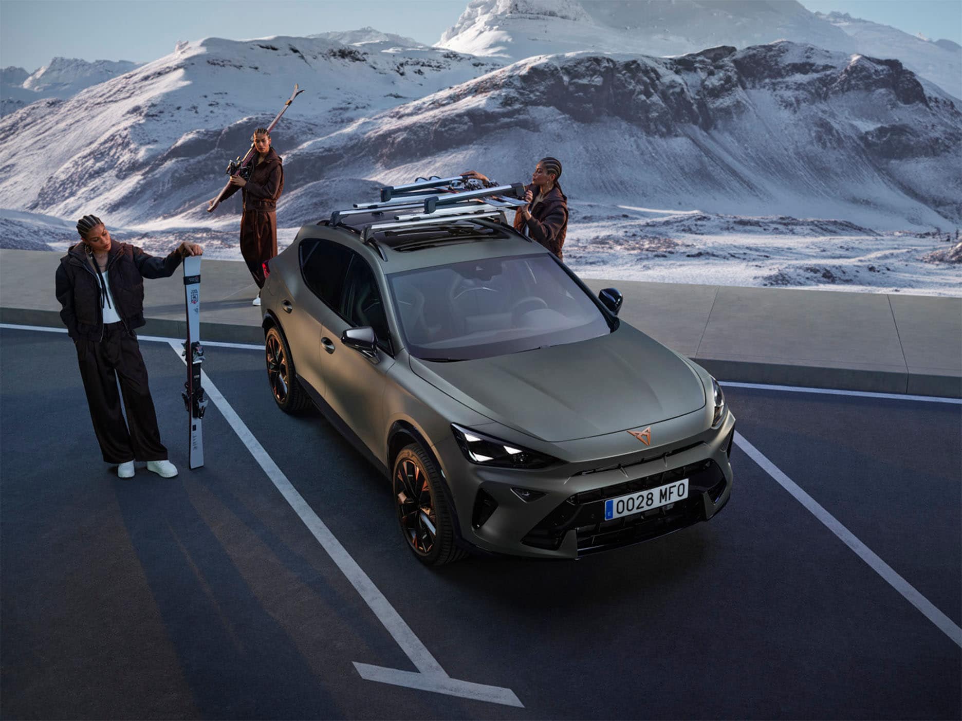 CUPRA Formentor parked in a snowy landscape with three individuals around it, including one using the roof bars from the accessory range.