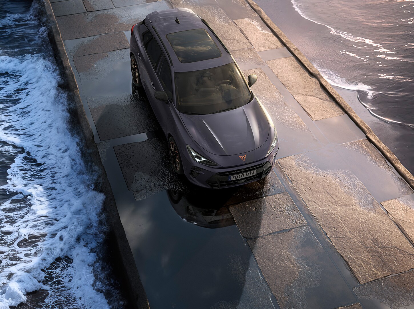 Upper shot of a CUPRA Terramar parked in a concrete surface surrounded by the sea.
