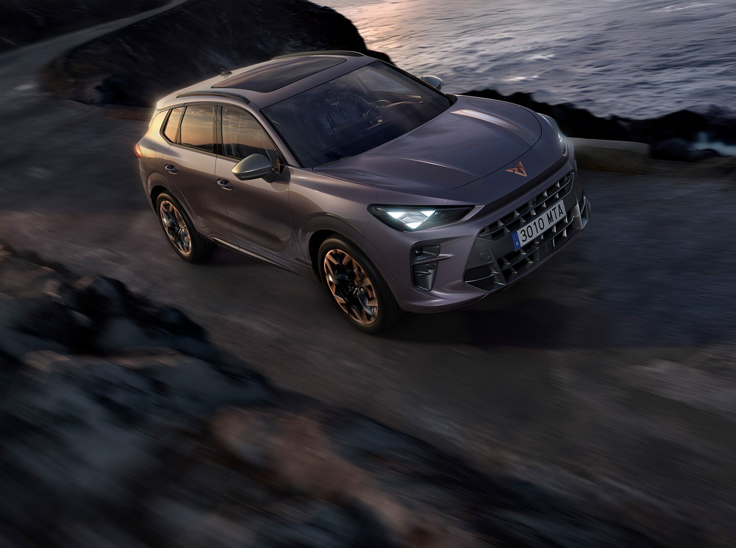 Side view of a CUPRA Terramar in a concrete surface surrounded by the sea.